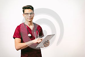 healthcare and medicine concept - young male doctor with stethoscope and tablet in hands