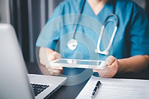 Healthcare and Medicine. Doctor using a digital tablet. Young woman doctor holding a tablet pc. Doctor working on a digital tablet