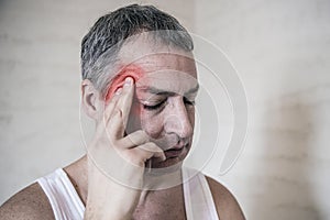 Healthcare, pain, stress, age and people concept -mature man suffering from headache at home