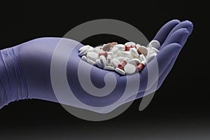 Healthcare personnel holding a pile of prescription pills, horizontal