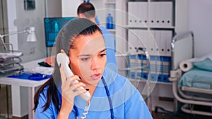 Healthcare physician answering telephone in hospital reception