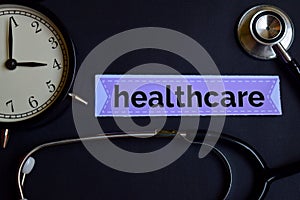 Healthcare on the print paper with Healthcare Concept Inspiration. alarm clock, Black stethoscope.