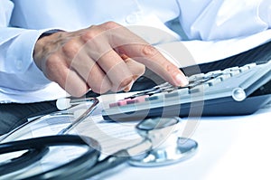 Healthcare professional calculating on an electronic calculator