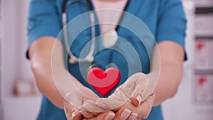 Healthcare professional holding heart shape in hand - medical service concept