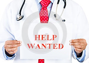 Healthcare professional holding up Help Wanted sign