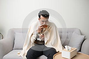 Healthcare, Traditional Medicine And Flu Concept - Man Takes Pill from Headache Sitting On Sofa. Sick man treating symptoms caused
