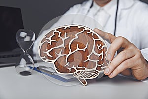 Healthcare and treatment concept. Doctor is showing wooden brain in his office