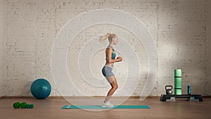 Healthcare and wellness advertisement concept. Athletic woman fitness coach doing lunges cross jumps for online classes.