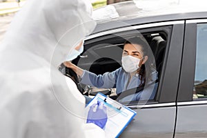 Healthcare worker with clipboard and woman in car