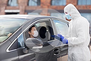 Healthcare worker with clipboard and woman in car