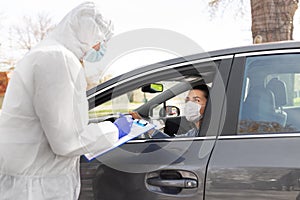 Healthcare worker with clipboard and woman in car