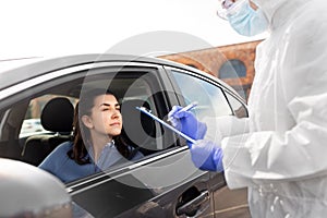 Healthcare worker with clipboard and woman in car