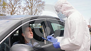 Healthcare worker with clipboard and woman in car