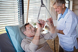 Healthcare worker helping paralysed senior patient in hospital. photo