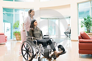 Healthcare Worker Leaving Female Patient In Hospital Lobby