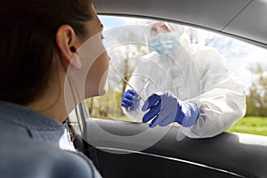 Healthcare worker making coronavirus test at car