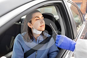 Healthcare worker making coronavirus test at car