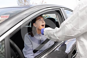 Healthcare worker making coronavirus test at car