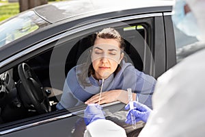 Healthcare worker making coronavirus test at car