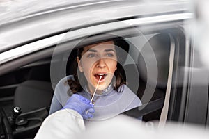 Healthcare worker making coronavirus test at car