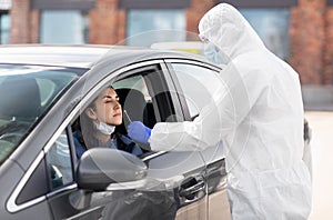 Healthcare worker making coronavirus test at car