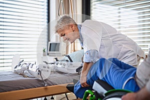 A healthcare worker and paralysed senior patient in hospital. photo