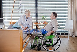 A healthcare worker and paralysed senior patient in hospital. photo