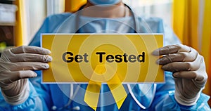 Healthcare worker promotes hepatitis awareness, holding a Get Tested sign and yellow ribbon