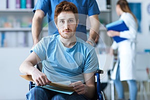 Healthcare worker pushing a man in wheelchair