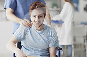 Healthcare worker pushing a man in wheelchair photo