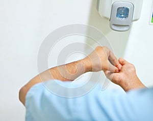 A healthcare worker rubbing the fingers with alcohol-based hand rub.