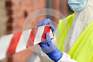 Healthcare worker sealing door with caution tape