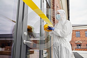 Healthcare worker sealing door with caution tape