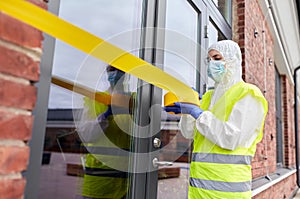 Healthcare worker sealing door with caution tape