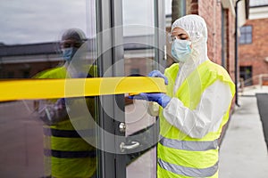 Healthcare worker sealing door with caution tape