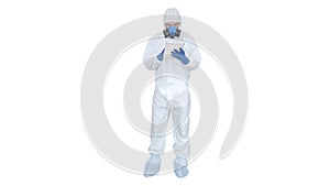 Healthcare worker wearing hazmat suit working on digital tablet on white background.