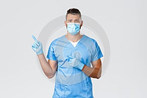 Healthcare workers, covid-19, coronavirus and preventing virus concept. Sad distressed male doctor, nurse in scrubs and