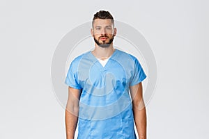 Healthcare workers, medicine, covid-19 and pandemic self-quarantine concept. Determined young doctor, physician in blue