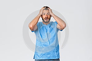 Healthcare workers, medicine, covid-19 and pandemic self-quarantine concept. Shocked and nervous male doctor, nurse in