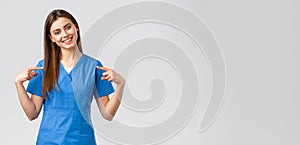 Healthcare workers, prevent virus and medicine concept. Cheerful, smiling pretty doctor, female nurse in blue scrubs