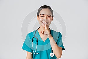 Healthcare workers, preventing virus, quarantine campaign concept. Smiling pretty asian doctor, nurse in scrubs smiling