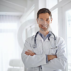 Healthcare you can trust. Portrait of a handsome male doctor standing with his arms folded.