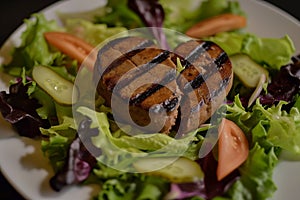 healthconscious salad topped with a sliced, grilled heart burger