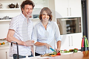 Healthiness is next to happiness. Portrait of a happy mature couple cooking a healthy meal together at home.