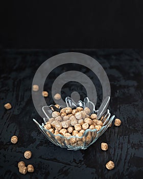 Healthly food. Bran balls in a decorative glass in a bowl on a black background