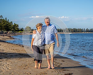 Healthy active senior couple holding hands, embracing each other and walking on beach