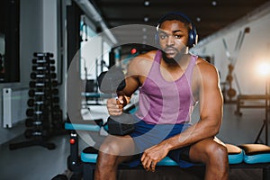 healthy african man working out with dumbbells in gym.