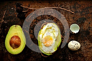 Healthy, alkaline breakfast with avocado sandwich and quail eggs on a grunge background