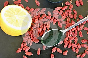 Healthy antioxidant and detox food, red Chinese berry goji, lemon, green spirulina, linseed