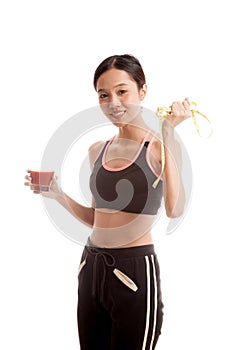 Healthy Asian girl diet with tomato juice and measuring tape on